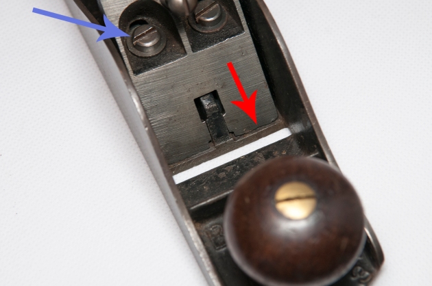 Figure 3 - Loosed the frog bolts (blue arrow) and position the frog so it aligns with the rear edge of the mouth (red arrow)